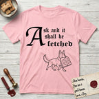 Ask and It Shall Be Fetched German Shepherd T-Shirt flat lay in Light Pink, featuring a sparse pen-and-ink illustration of a German Shepherd at a proud trot carrying a pair of stone tablets.