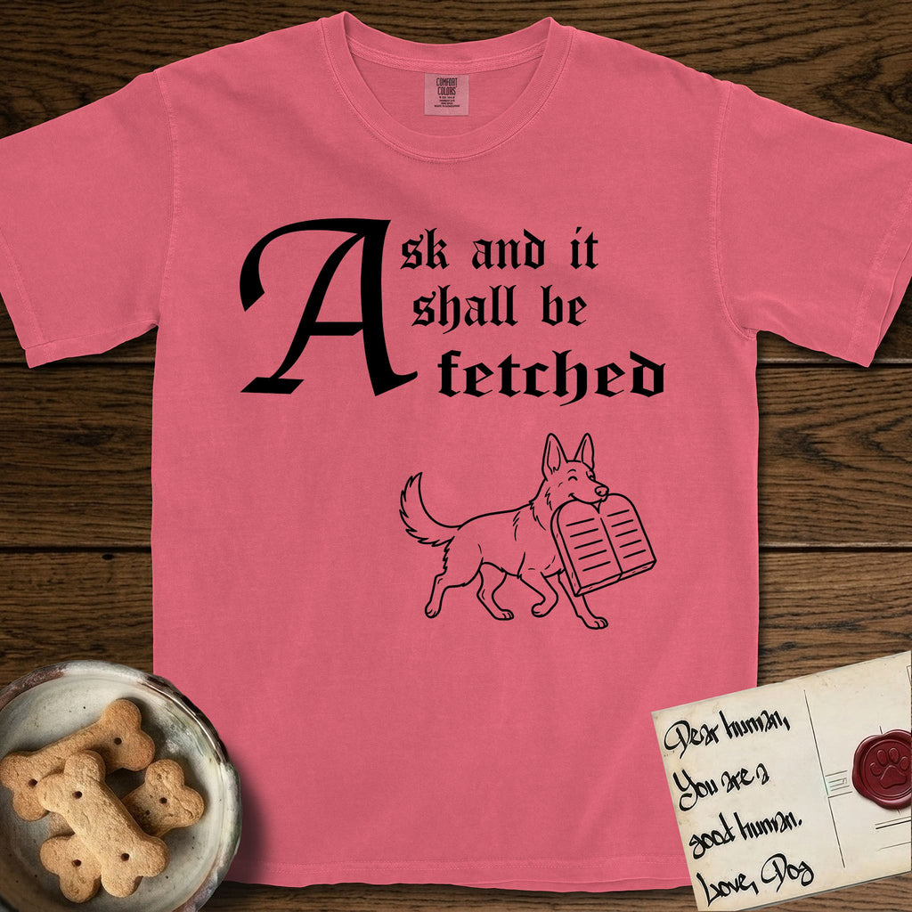 Ask and It Shall Be Fetched German Shepherd T-Shirt flat lay in Watermelon, featuring a sparse pen-and-ink illustration of a German Shepherd at a proud trot carrying a pair of stone tablets.