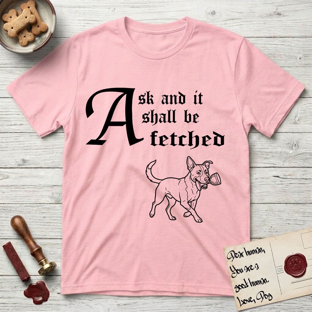 Ask and It Shall Be Fetched Lobo T-Shirt flat lay in Light Pink, featuring a sparse pen-and-ink illustration of Lobo, a black-and-white Australian Cattle Dog and Pitbull mix, at a proud trot carrying a chalice.