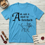 Ask and It Shall Be Fetched Lobo T-Shirt flat lay in Sky, featuring a sparse pen-and-ink illustration of Lobo, a black-and-white Australian Cattle Dog and Pitbull mix, at a proud trot carrying a chalice.