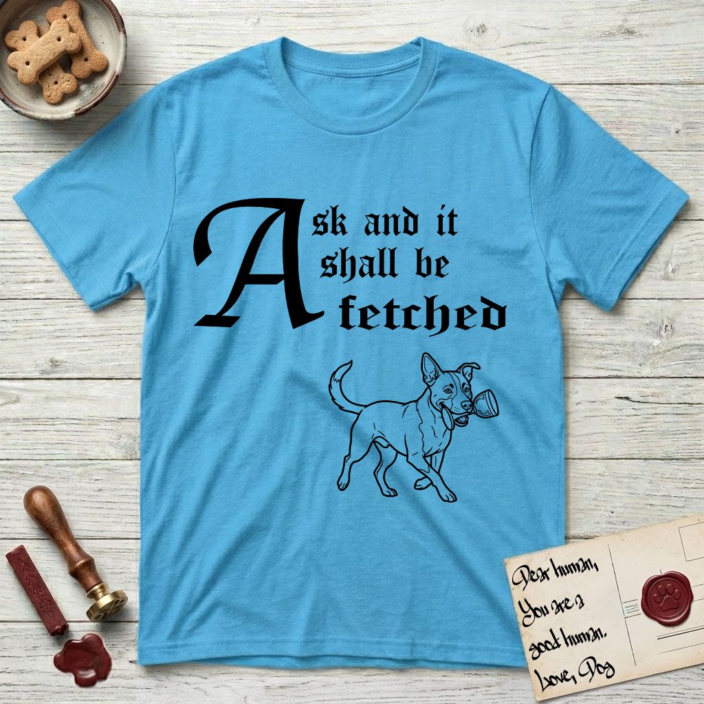 Ask and It Shall Be Fetched Lobo T-Shirt flat lay in Sky, featuring a sparse pen-and-ink illustration of Lobo, a black-and-white Australian Cattle Dog and Pitbull mix, at a proud trot carrying a chalice.