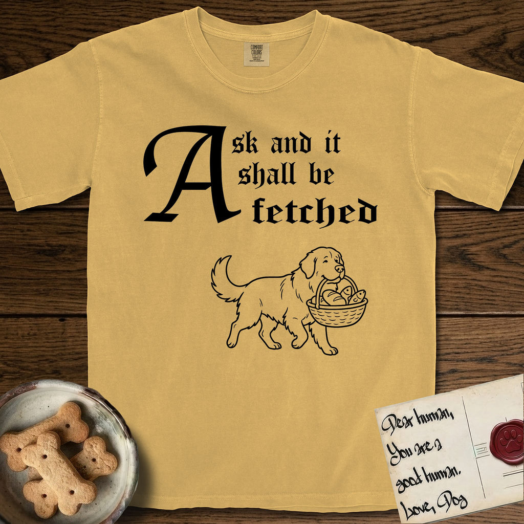 Ask and It Shall Be Fetched Newfoundland T-Shirt flat lay in Mustard, featuring a sparse pen-and-ink illustration of a Newfoundland at a proud trot carrying loaves and fishes.