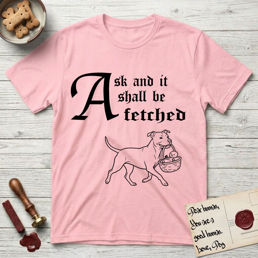 Ask and It Shall Be Fetched Pitbull T-Shirt flat lay in Light Pink, featuring a sparse pen-and-ink illustration of a Pitbull at a proud trot carrying a baby in a reed basket.