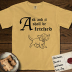 Ask and It Shall Be Fetched Spaniel T-Shirt flat lay in Mustard, featuring a sparse pen-and-ink illustration of a Spaniel at a proud trot carrying a dove with an olive branch.