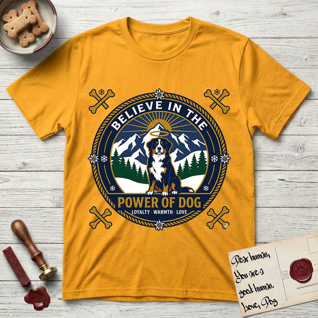 Believe in the Power of Dog Bernese Mountain Dog T-Shirt flat lay in Gold, featuring a circular national-park-style badge with a haloed Bernese Mountain Dog, a mountain scene, a rope border, and the words Loyalty, Warmth, Love.