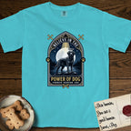 Believe in the Power of Dog Black Lab T-Shirt flat lay in Lagoon Blue, featuring a dramatic gothic-arch badge with a moonlit Black Lab on a rock above still water, a beam of light through the arch, and the words Strength, Devotion, Love.