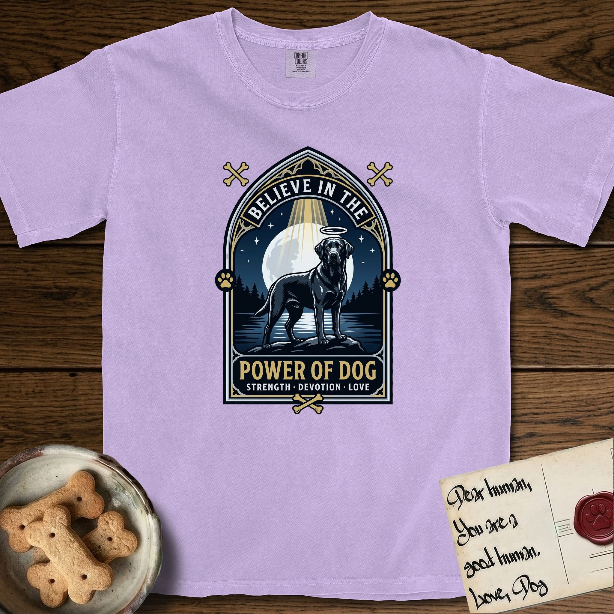 Believe in the Power of Dog Black Lab T-Shirt flat lay in Orchid, featuring a dramatic gothic-arch badge with a moonlit Black Lab on a rock above still water, a beam of light through the arch, and the words Strength, Devotion, Love.