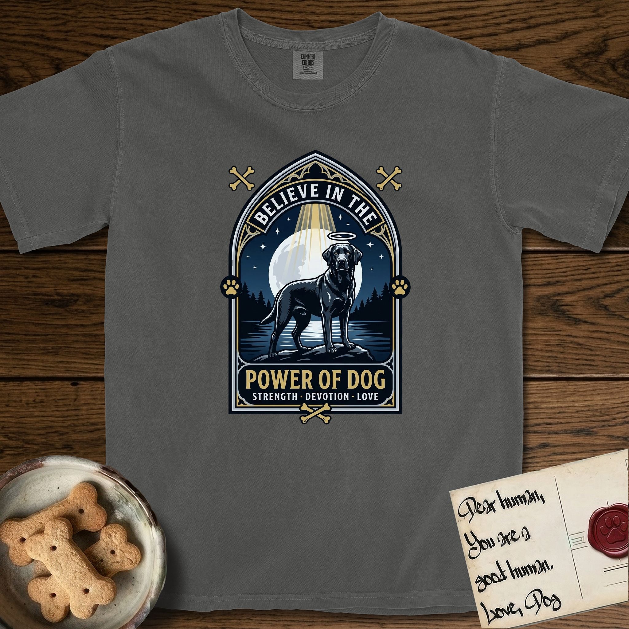 Believe in the Power of Dog Black Lab T-Shirt flat lay in Pepper, featuring a dramatic gothic-arch badge with a moonlit Black Lab on a rock above still water, a beam of light through the arch, and the words Strength, Devotion, Love.