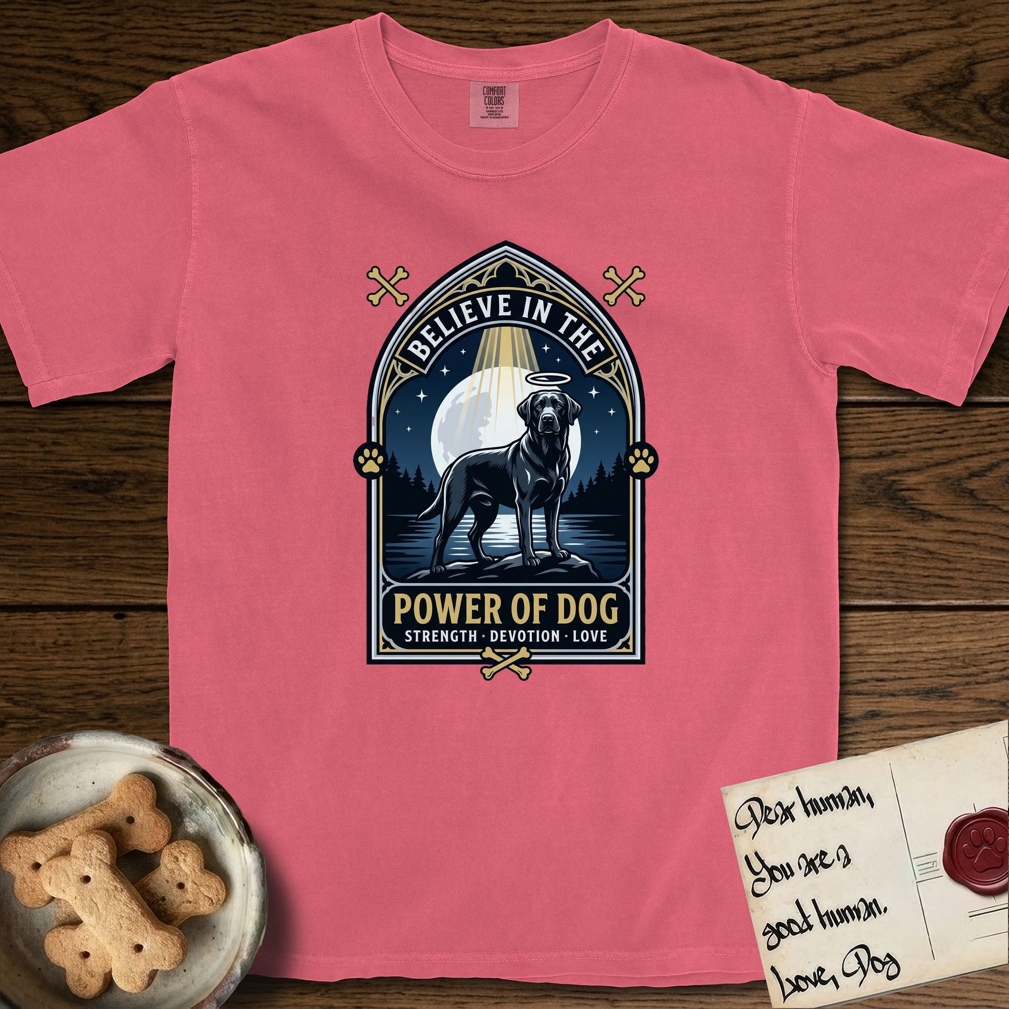 Believe in the Power of Dog Black Lab T-Shirt flat lay in Watermelon, featuring a dramatic gothic-arch badge with a moonlit Black Lab on a rock above still water, a beam of light through the arch, and the words Strength, Devotion, Love.
