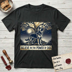 Believe in the Power of Dog German Shepherd T-Shirt flat lay in Black, featuring a moonlit illustration of a German Shepherd standing beneath a great tree whose roots and branches reach equally in both directions.
