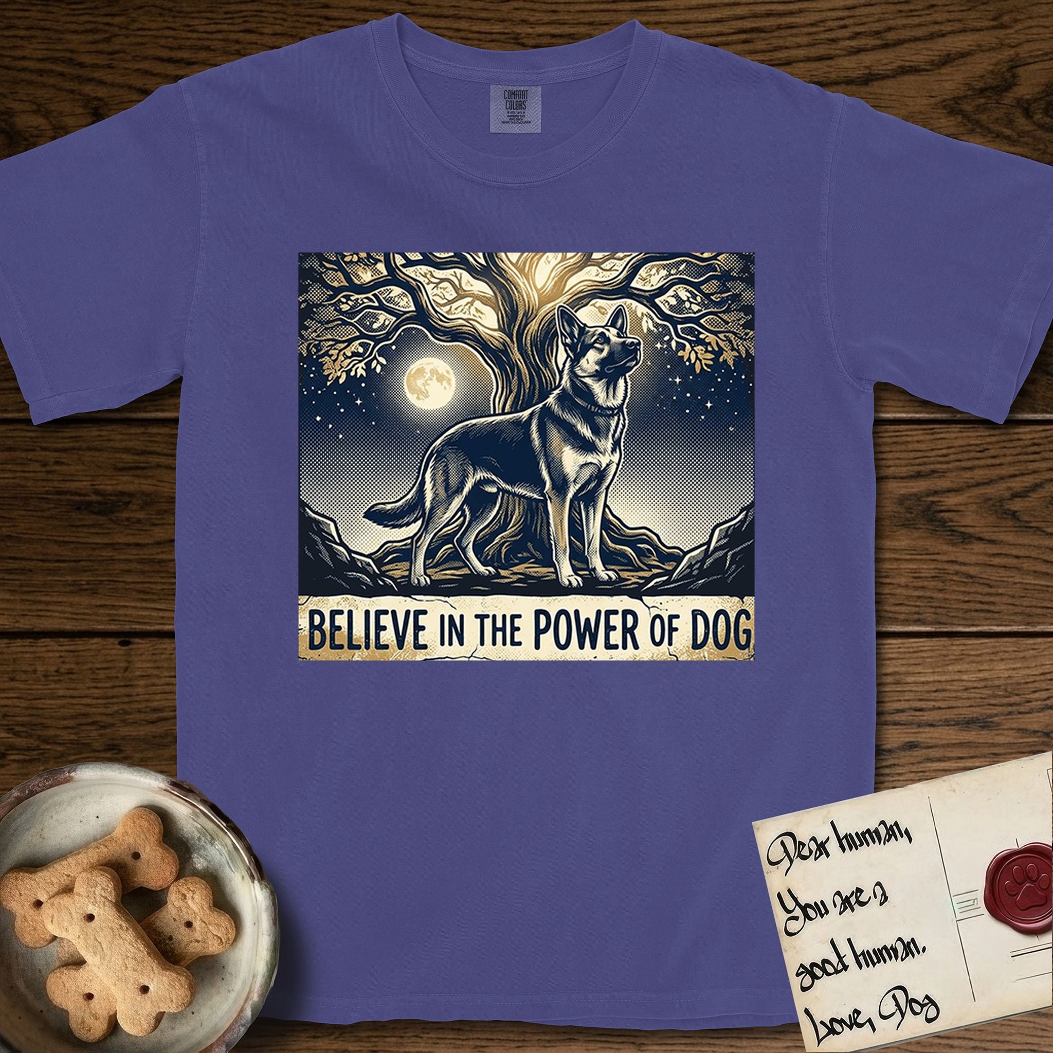 Believe in the Power of Dog German Shepherd T-Shirt flat lay in Grape, featuring a moonlit illustration of a German Shepherd standing beneath a great tree whose roots and branches reach equally in both directions.
