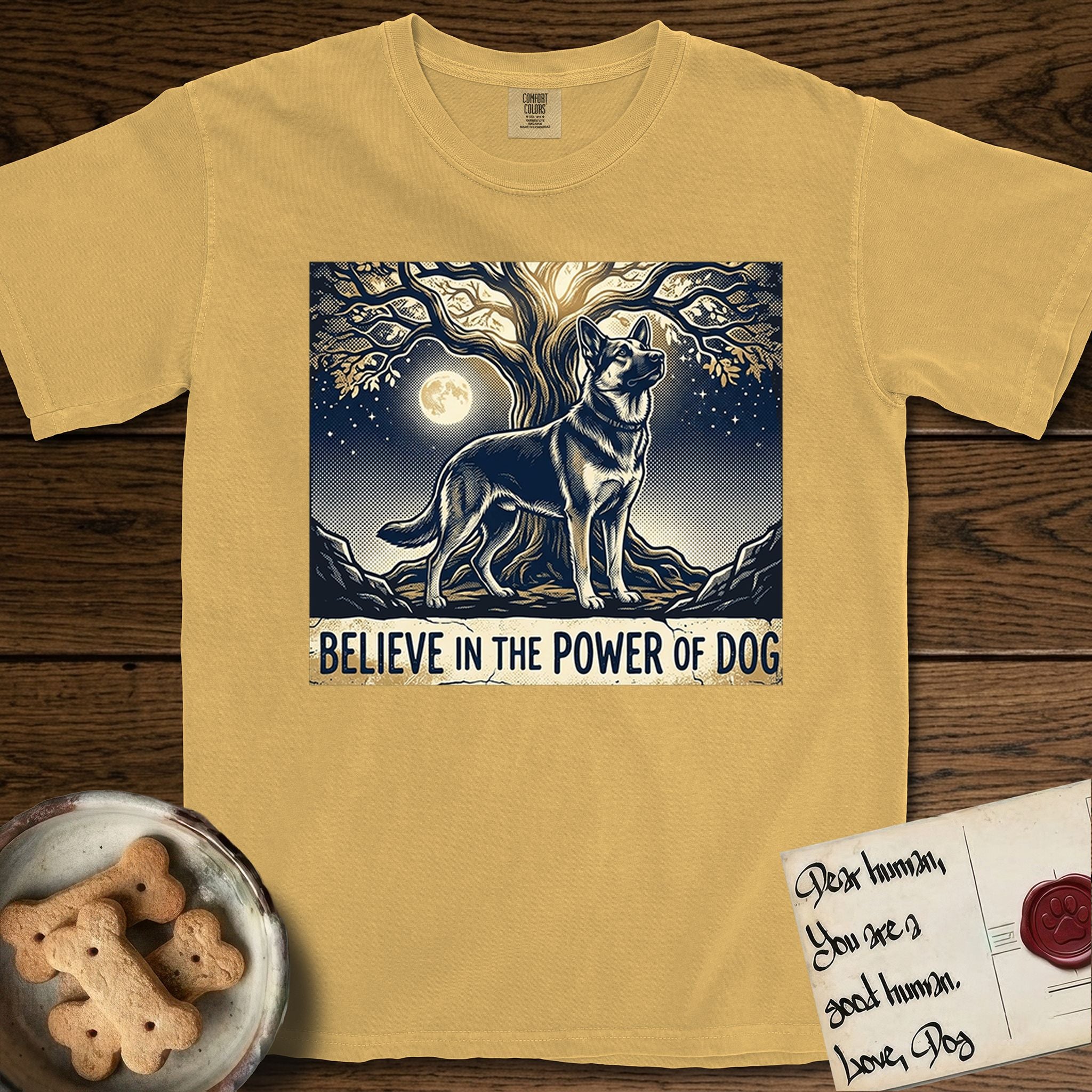 Believe in the Power of Dog German Shepherd T-Shirt flat lay in Mustard, featuring a moonlit illustration of a German Shepherd standing beneath a great tree whose roots and branches reach equally in both directions.