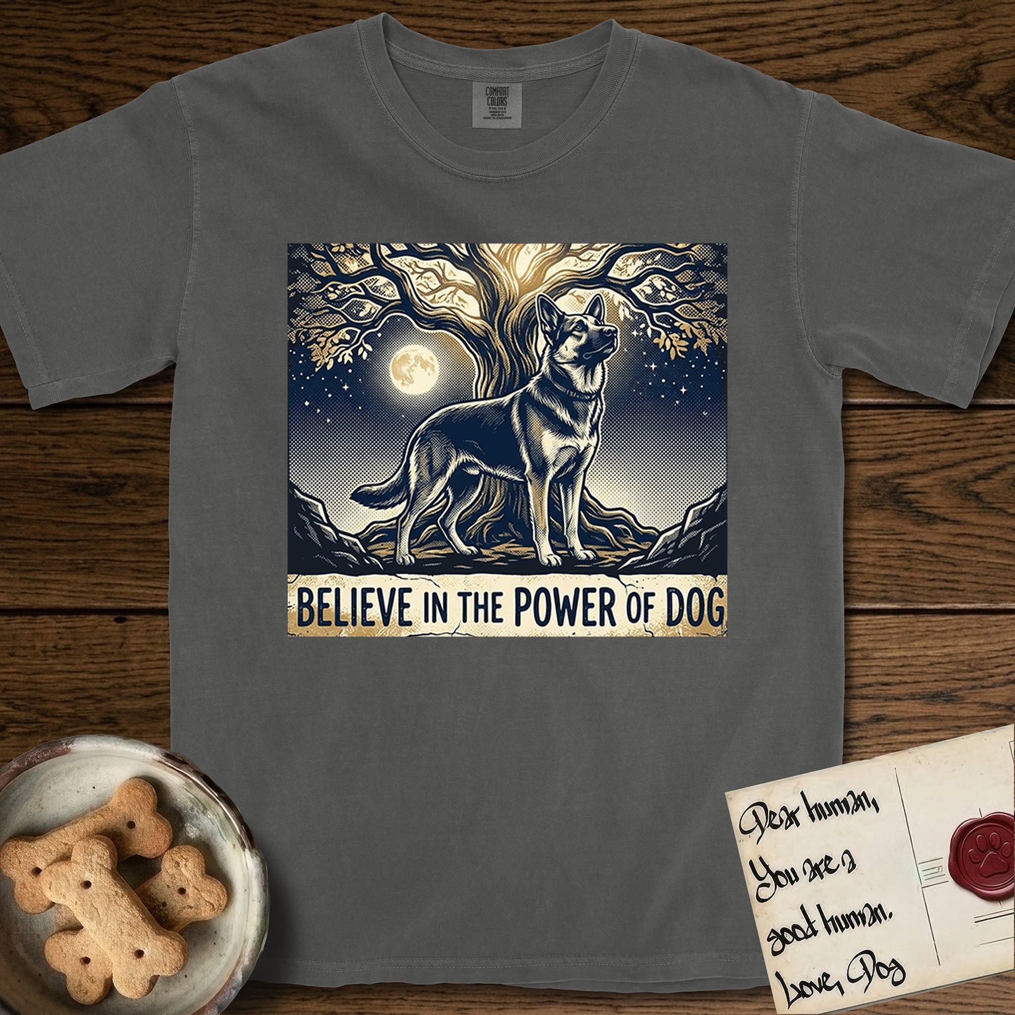 Believe in the Power of Dog German Shepherd T-Shirt flat lay in Pepper, featuring a moonlit illustration of a German Shepherd standing beneath a great tree whose roots and branches reach equally in both directions.