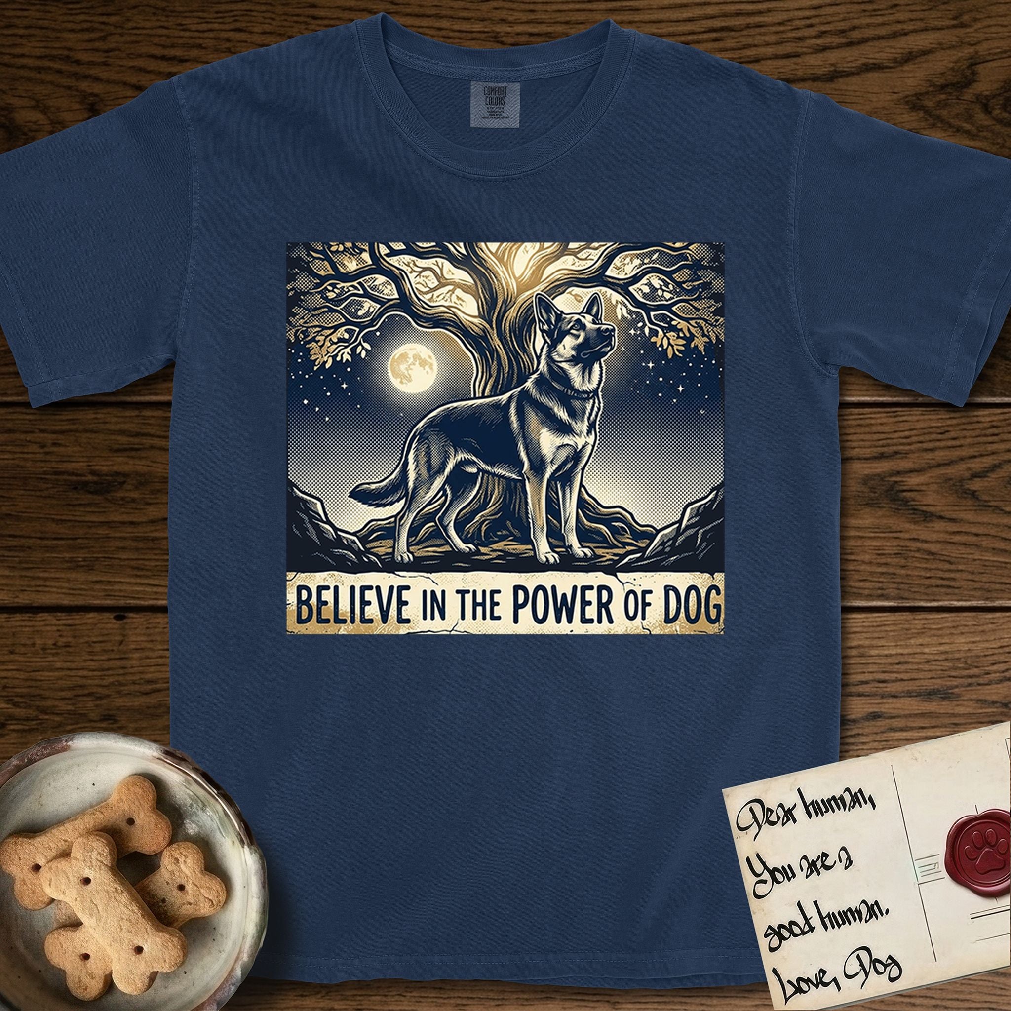 Believe in the Power of Dog German Shepherd T-Shirt flat lay in True Navy, featuring a moonlit illustration of a German Shepherd standing beneath a great tree whose roots and branches reach equally in both directions.