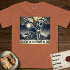 Believe in the Power of Dog German Shepherd T-Shirt flat lay in Yam, featuring a moonlit illustration of a German Shepherd standing beneath a great tree whose roots and branches reach equally in both directions.