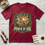 Believe in the Power of Dog Golden Retriever T-Shirt flat lay in Antique Cherry Red, featuring a vintage outdoor badge with a haloed Golden Retriever standing on a rock above the treeline at sunrise and the words Faith, Loyalty, Love.