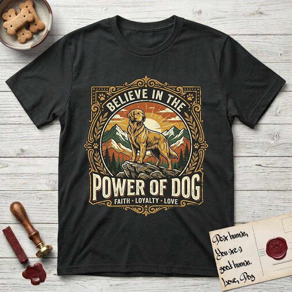 Believe in the Power of Dog Golden Retriever T-Shirt flat lay in Black, featuring a vintage outdoor badge with a haloed Golden Retriever standing on a rock above the treeline at sunrise and the words Faith, Loyalty, Love.