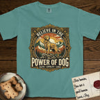 Believe in the Power of Dog Golden Retriever T-Shirt flat lay in Blue Spruce, featuring a vintage outdoor badge with a haloed Golden Retriever standing on a rock above the treeline at sunrise and the words Faith, Loyalty, Love.