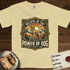 Believe in the Power of Dog Golden Retriever T-Shirt flat lay in Butter, featuring a vintage outdoor badge with a haloed Golden Retriever standing on a rock above the treeline at sunrise and the words Faith, Loyalty, Love.