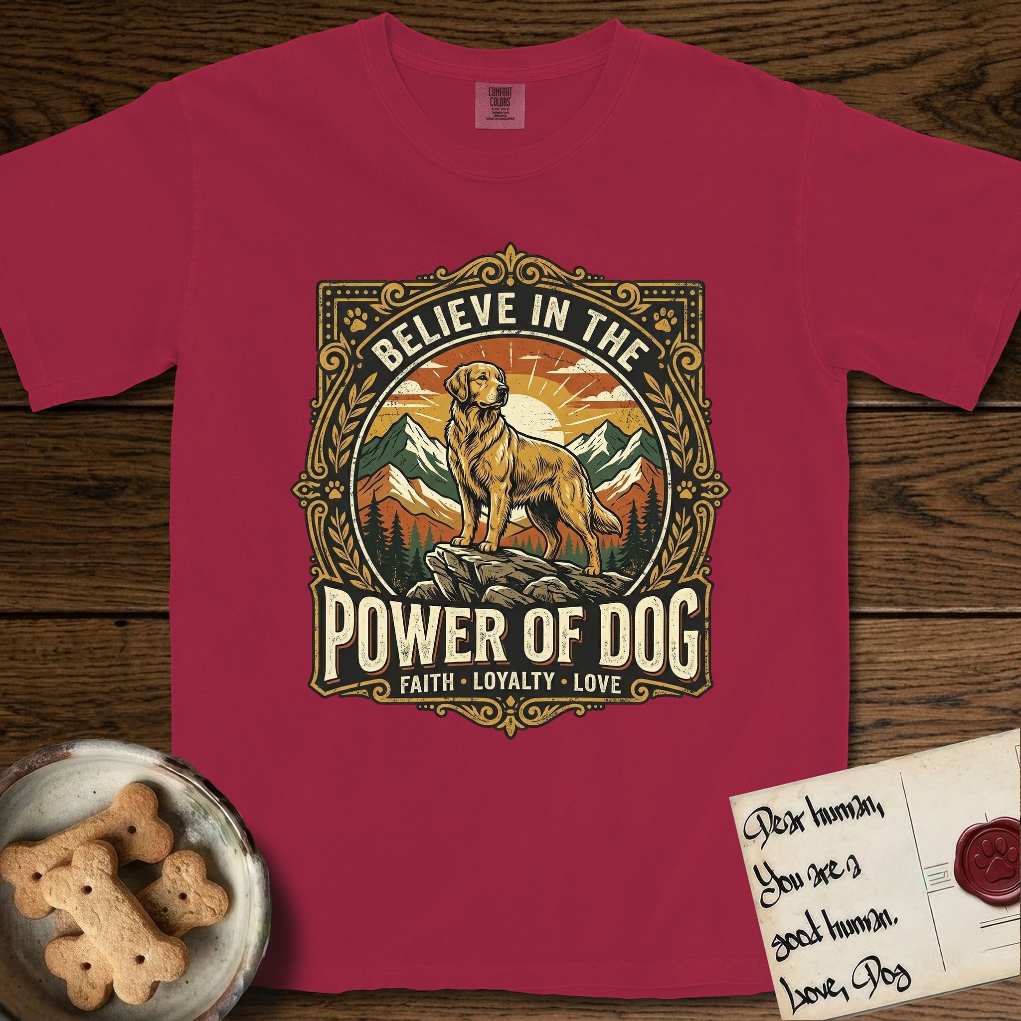 Believe in the Power of Dog Golden Retriever T-Shirt flat lay in Chili, featuring a vintage outdoor badge with a haloed Golden Retriever standing on a rock above the treeline at sunrise and the words Faith, Loyalty, Love.