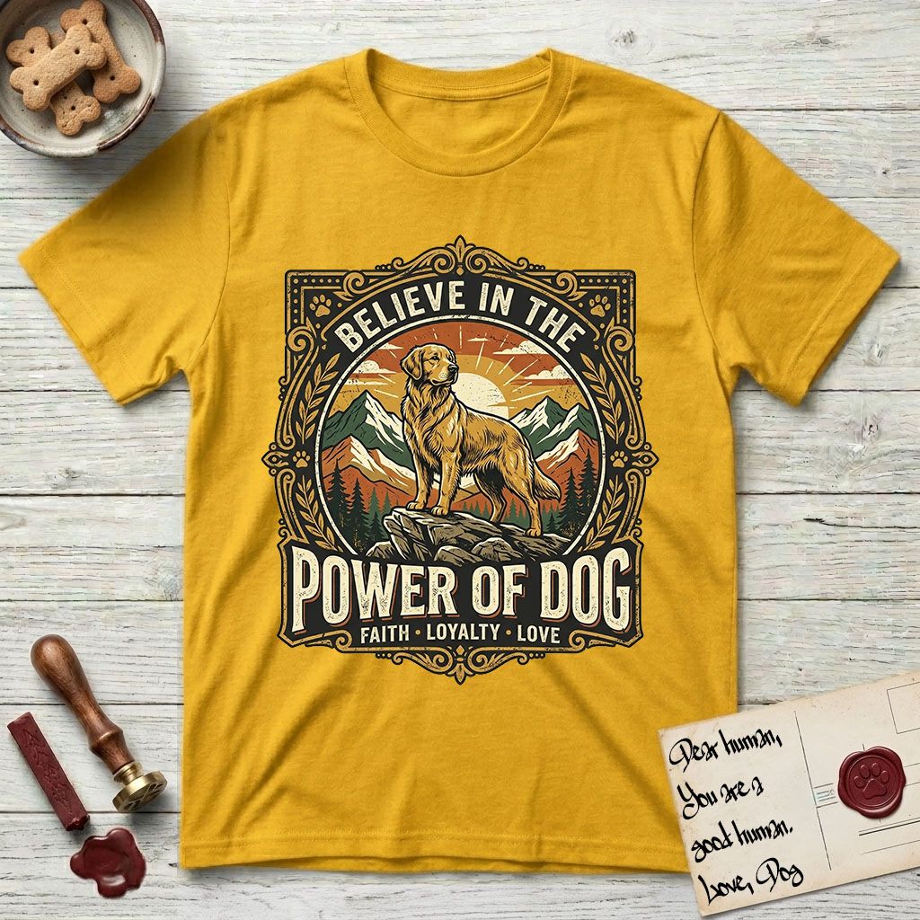 Believe in the Power of Dog Golden Retriever T-Shirt flat lay in Daisy, featuring a vintage outdoor badge with a haloed Golden Retriever standing on a rock above the treeline at sunrise and the words Faith, Loyalty, Love.