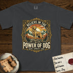 Believe in the Power of Dog Golden Retriever T-Shirt flat lay in Graphite, featuring a vintage outdoor badge with a haloed Golden Retriever standing on a rock above the treeline at sunrise and the words Faith, Loyalty, Love.