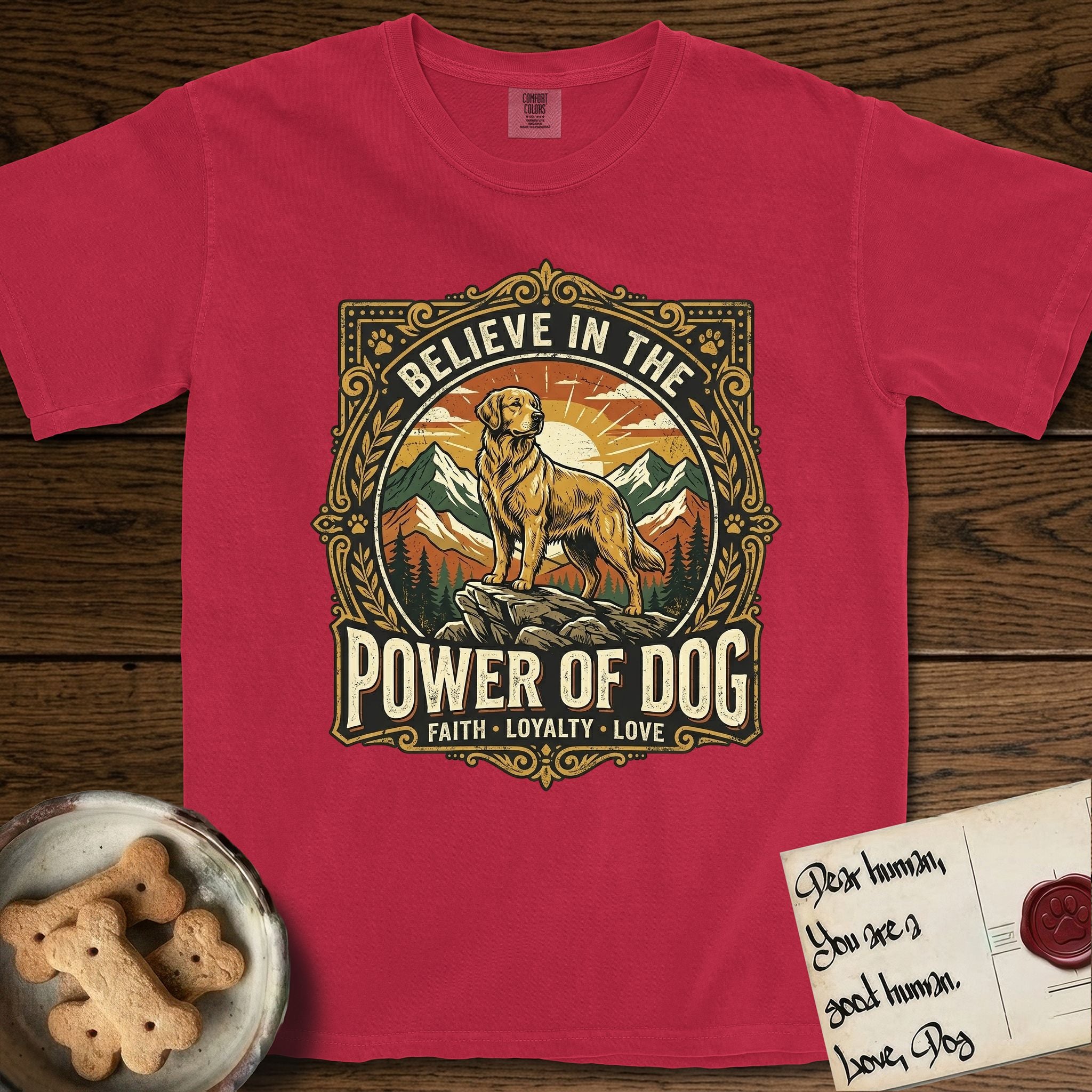 Believe in the Power of Dog Golden Retriever T-Shirt flat lay in Red, featuring a vintage outdoor badge with a haloed Golden Retriever standing on a rock above the treeline at sunrise and the words Faith, Loyalty, Love.