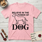 Believe in the Power of Dog Labrador T-Shirt flat lay in Light Pink, featuring stark minimalist single-line art of a Labrador with bold stacked "Believe in the Power of Dog" type and a paw-print heart in the O.