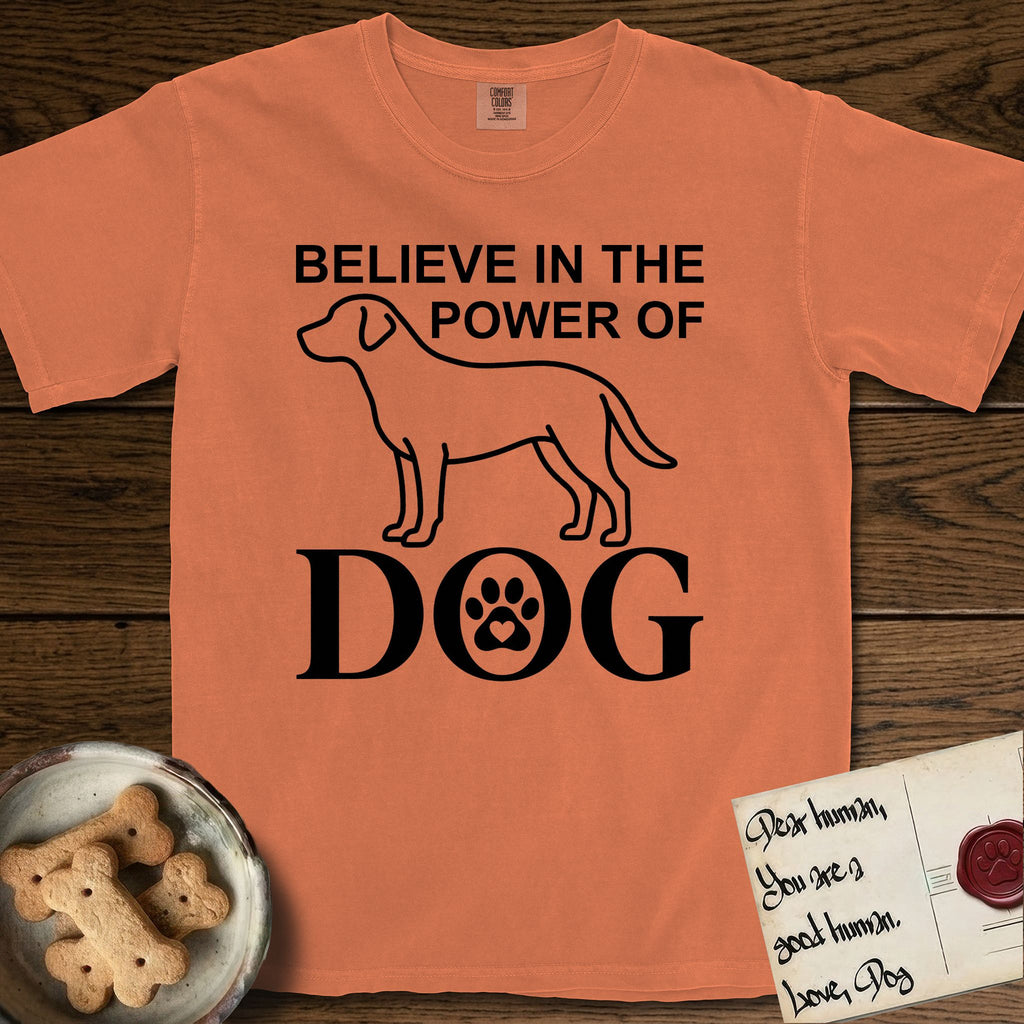 Believe in the Power of Dog Labrador T-Shirt flat lay in Melon, featuring stark minimalist single-line art of a Labrador with bold stacked "Believe in the Power of Dog" type and a paw-print heart in the O.