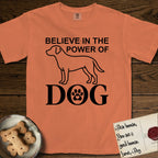 Believe in the Power of Dog Labrador T-Shirt flat lay in Melon, featuring stark minimalist single-line art of a Labrador with bold stacked "Believe in the Power of Dog" type and a paw-print heart in the O.