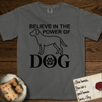 Believe in the Power of Dog Labrador T-Shirt flat lay in Pepper, featuring stark minimalist single-line art of a Labrador with bold stacked "Believe in the Power of Dog" type and a paw-print heart in the O.