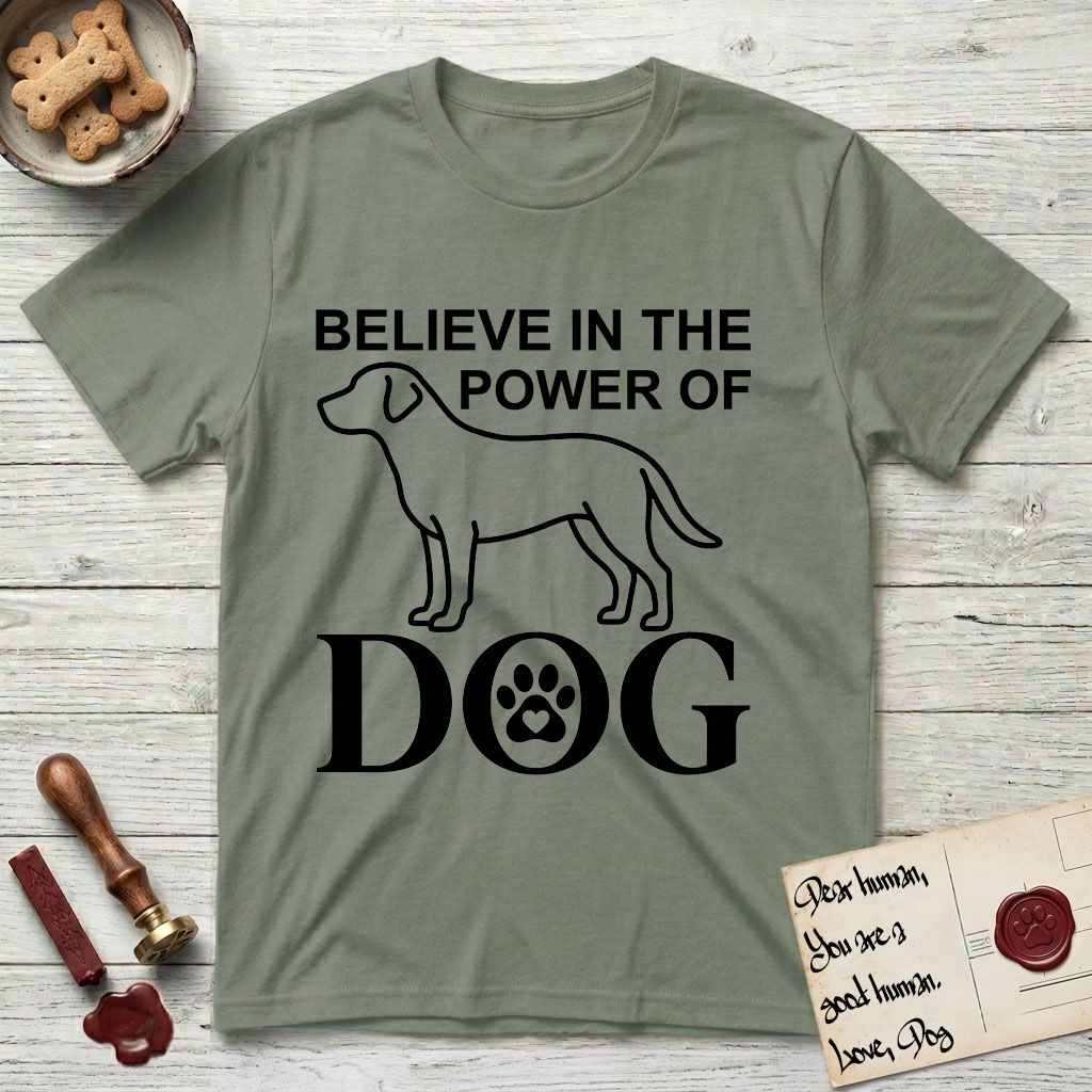 Believe in the Power of Dog Labrador T-Shirt flat lay in Sage, featuring stark minimalist single-line art of a Labrador with bold stacked "Believe in the Power of Dog" type and a paw-print heart in the O.