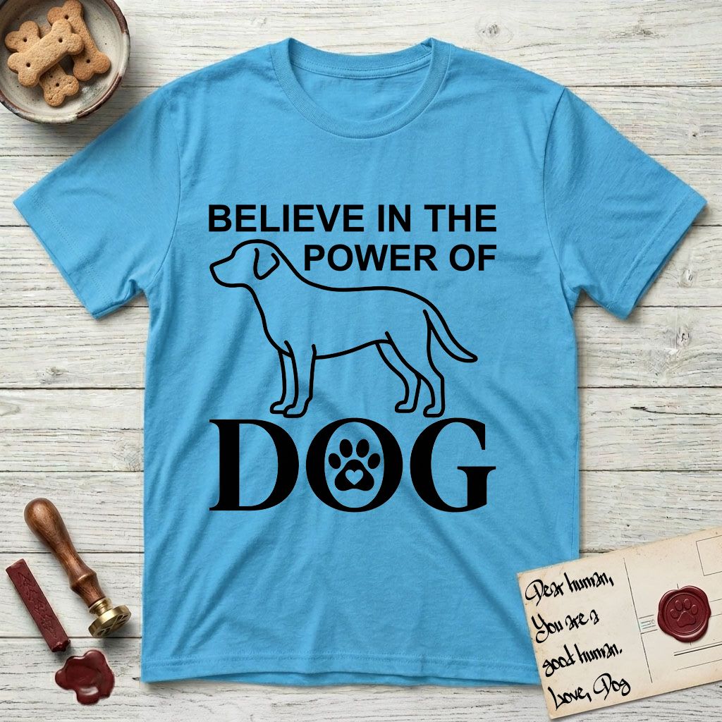 Believe in the Power of Dog Labrador T-Shirt flat lay in Sky, featuring stark minimalist single-line art of a Labrador with bold stacked "Believe in the Power of Dog" type and a paw-print heart in the O.