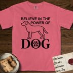 Believe in the Power of Dog Labrador T-Shirt flat lay in Watermelon, featuring stark minimalist single-line art of a Labrador with bold stacked "Believe in the Power of Dog" type and a paw-print heart in the O.
