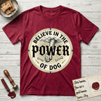 Believe in the Power of Dog Paw T-Shirt flat lay in Antique Cherry Red, featuring a vintage engraving medallion of a Dog paw and a human hand meeting over crossed bones in a sunburst.