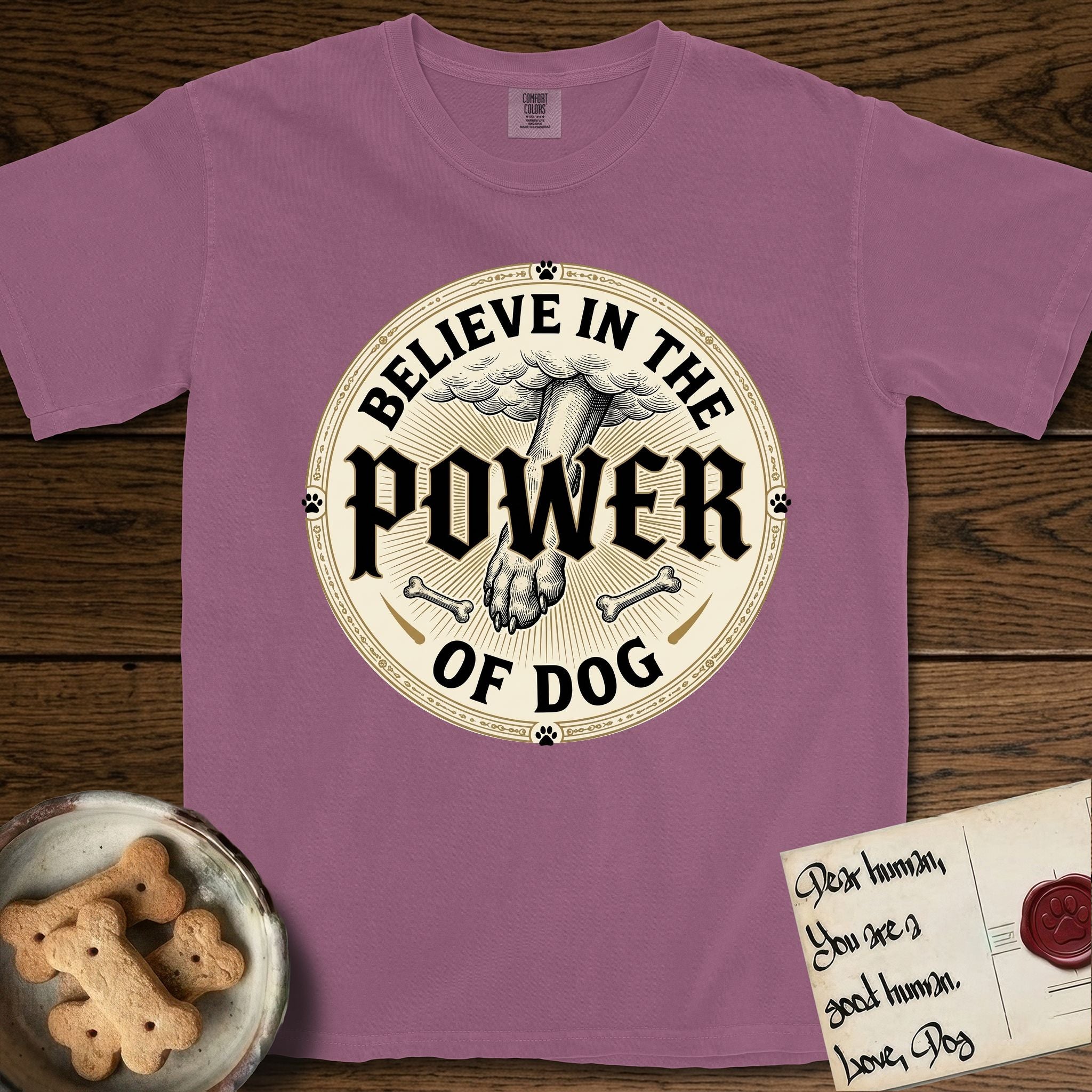 Believe in the Power of Dog Paw T-Shirt flat lay in Berry, featuring a vintage engraving medallion of a Dog paw and a human hand meeting over crossed bones in a sunburst.