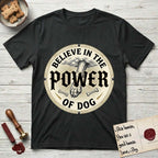 Believe in the Power of Dog Paw T-Shirt flat lay in Black, featuring a vintage engraving medallion of a Dog paw and a human hand meeting over crossed bones in a sunburst.