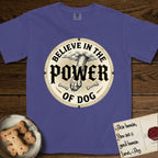 Believe in the Power of Dog Paw T-Shirt flat lay in Grape, featuring a vintage engraving medallion of a Dog paw and a human hand meeting over crossed bones in a sunburst.