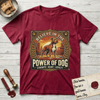 Believe in the Power of Dog Pitbull Cityscape T-Shirt flat lay in Antique Cherry Red, featuring a vintage urban badge with a brick-red Pitbull, a city skyline, a radiating sun, and the words Strength, Heart, Loyalty.