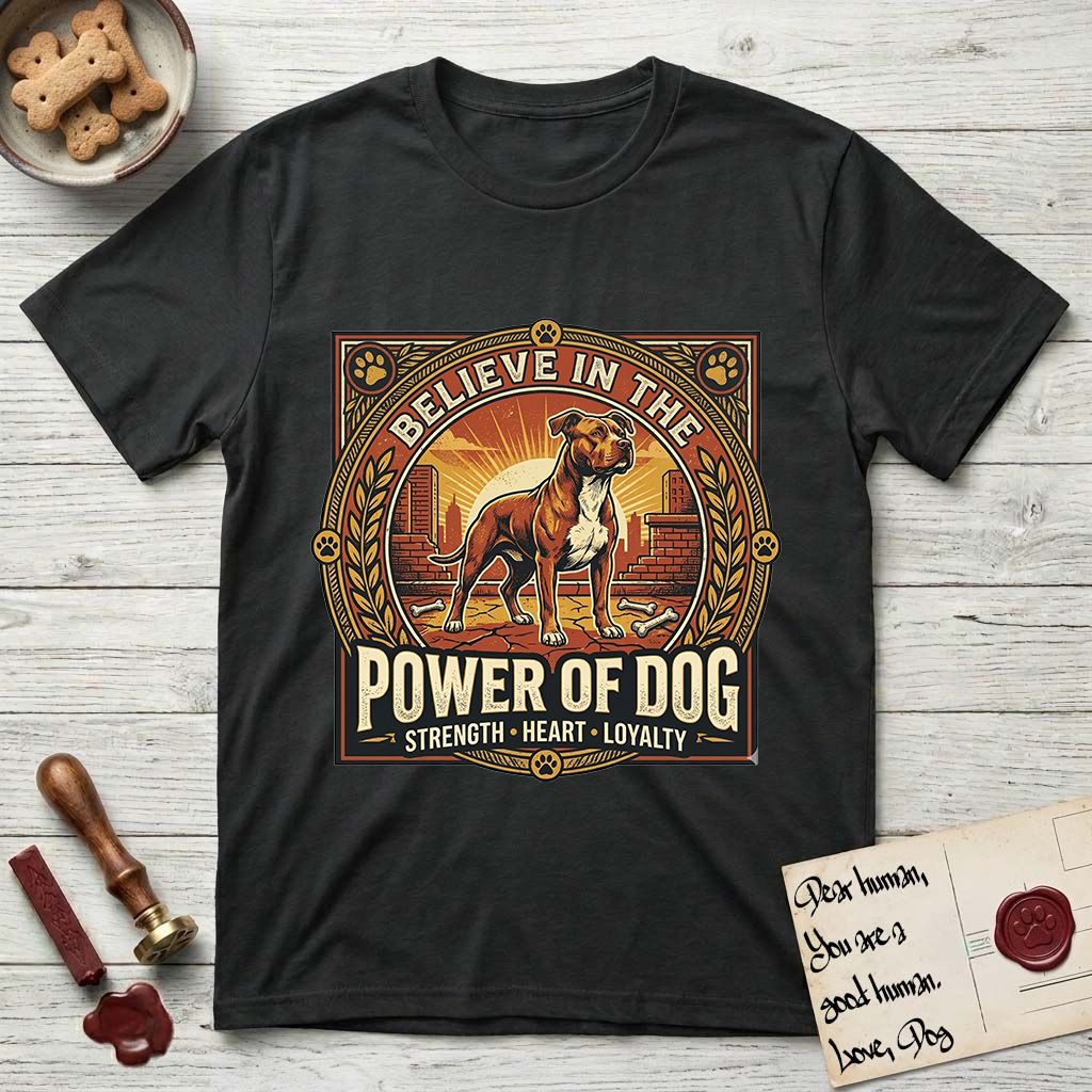 Believe in the Power of Dog Pitbull Cityscape T-Shirt flat lay in Black, featuring a vintage urban badge with a brick-red Pitbull, a city skyline, a radiating sun, and the words Strength, Heart, Loyalty.
