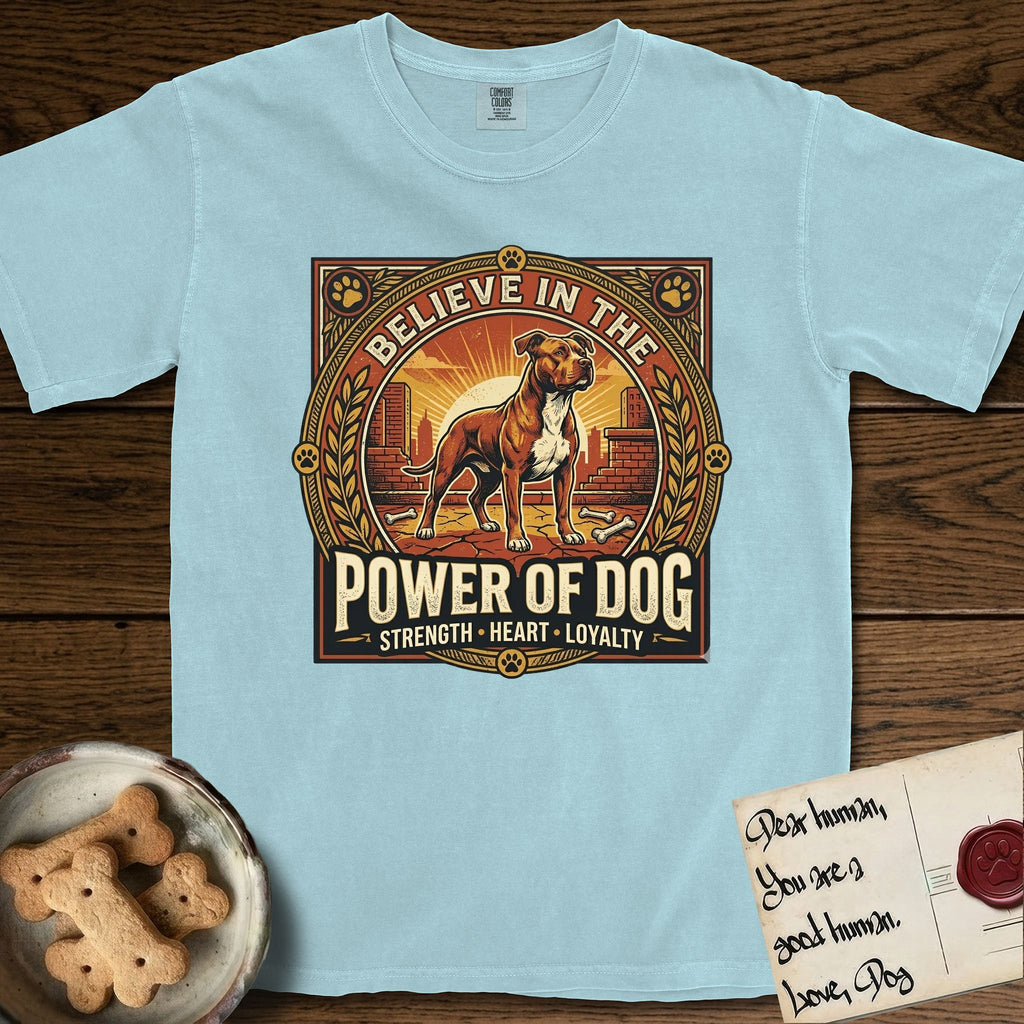 Believe in the Power of Dog Pitbull T-Shirt flat lay in Chambray, featuring a vintage urban badge with a brick-red Pitbull, a city skyline, a radiating sun, and the words Strength, Heart, Loyalty.