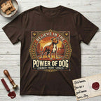 Believe in the Power of Dog Pitbull Cityscape T-Shirt flat lay in Dark Chocolate, featuring a vintage urban badge with a brick-red Pitbull, a city skyline, a radiating sun, and the words Strength, Heart, Loyalty.