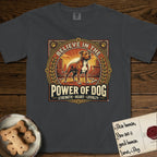 Believe in the Power of Dog Pitbull T-Shirt flat lay in Graphite, featuring a vintage urban badge with a brick-red Pitbull, a city skyline, a radiating sun, and the words Strength, Heart, Loyalty.
