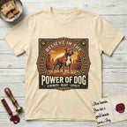 Believe in the Power of Dog Pitbull Cityscape T-Shirt flat lay in Natural, featuring a vintage urban badge with a brick-red Pitbull, a city skyline, a radiating sun, and the words Strength, Heart, Loyalty.