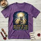 Believe in the Power of Dog Pitbull Clouds T-Shirt flat lay in Heather Purple, featuring a devotional badge with a seated Pitbull, parting clouds and radiating light, and the words Strength, Resilience, Redemption.