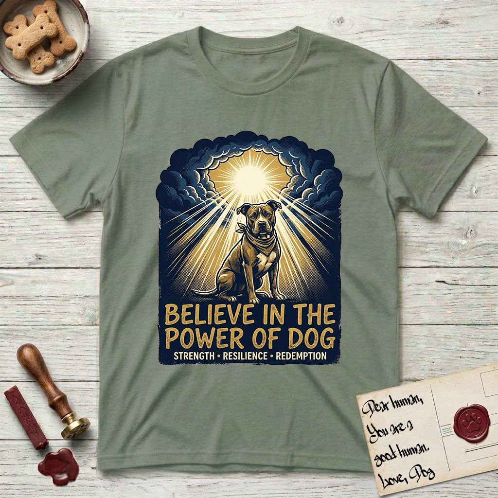 Believe in the Power of Dog Pitbull Clouds T-Shirt flat lay in Sage, featuring a devotional badge with a seated Pitbull, parting clouds and radiating light, and the words Strength, Resilience, Redemption.
