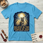 Believe in the Power of Dog Pitbull Clouds T-Shirt flat lay in Sky, featuring a devotional badge with a seated Pitbull, parting clouds and radiating light, and the words Strength, Resilience, Redemption.