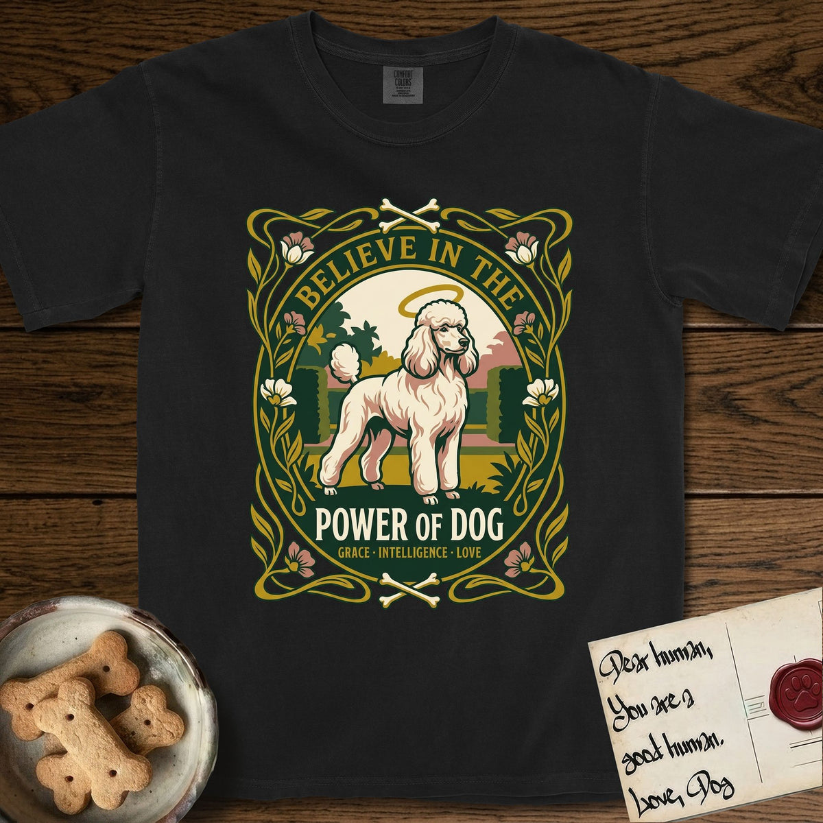 Believe in the Power of Dog Poodle T-Shirt flat lay in Black, featuring an Art Nouveau floral badge with a haloed Poodle in a garden park scene and the words Grace, Intelligence, Love.
