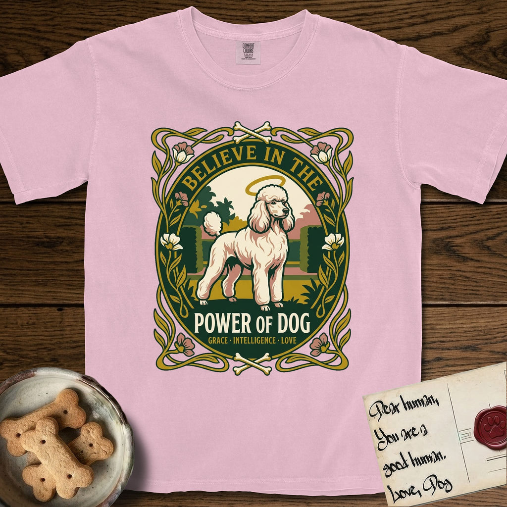 Believe in the Power of Dog Poodle T-Shirt flat lay in Blossom, featuring an Art Nouveau floral badge with a haloed Poodle in a garden park scene and the words Grace, Intelligence, Love.