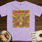 Believe in the Power of Dog Rescue Mutt T-Shirt flat lay in Orchid, featuring a retro 1970s groovy poster of a grinning rescue mutt with a radiating sunburst and swirling florals.
